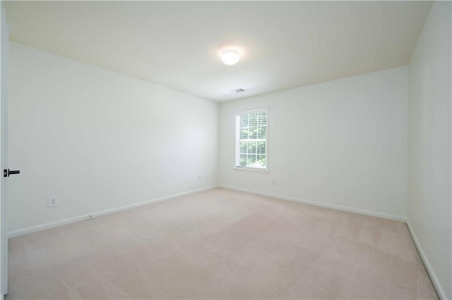 unfurnished room with baseboards, visible vents, and light colored carpet