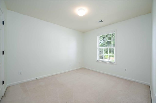 empty room with light colored carpet, visible vents, and baseboards