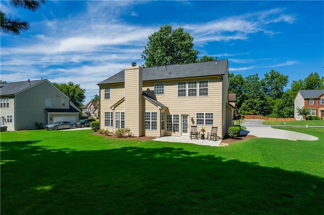 back of house with a yard, a chimney, and a patio