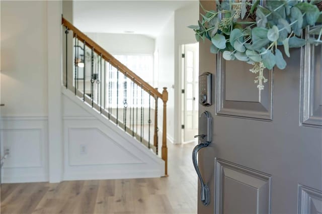 stairway featuring a decorative wall and wood finished floors