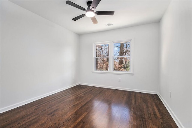 empty room with dark hardwood / wood-style floors and ceiling fan