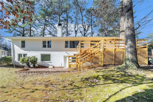 back of house featuring a wooden deck and a yard