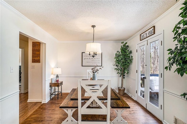 dining room featuring wood finished floors, crown molding, french doors, and visible vents