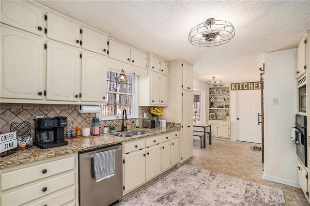 kitchen with oven, a sink, a textured ceiling, stainless steel dishwasher, and tasteful backsplash
