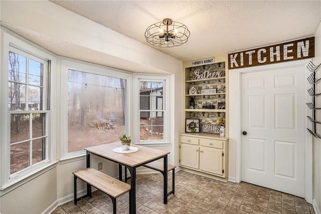 dining room with a textured ceiling and baseboards