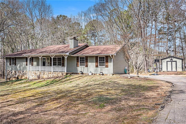 ranch-style house with a front lawn, a porch, a shed, an outdoor structure, and a chimney