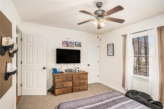 bedroom featuring baseboards, ceiling fan, a textured ceiling, and carpet