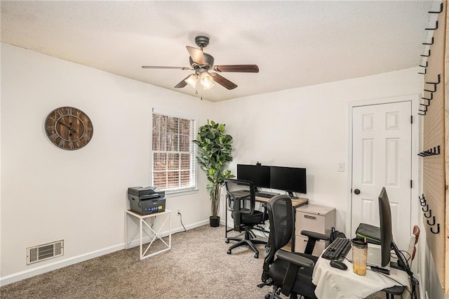 office with visible vents, light carpet, a ceiling fan, a textured ceiling, and baseboards