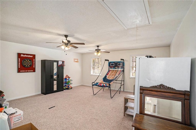 game room featuring carpet, baseboards, attic access, ceiling fan, and a textured ceiling