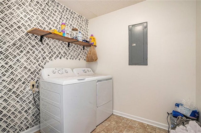 clothes washing area featuring electric panel, separate washer and dryer, laundry area, baseboards, and an accent wall