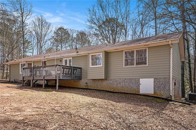 rear view of property with central AC unit and a wooden deck