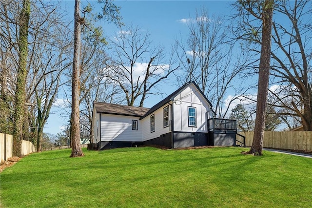 view of property exterior with fence and a lawn