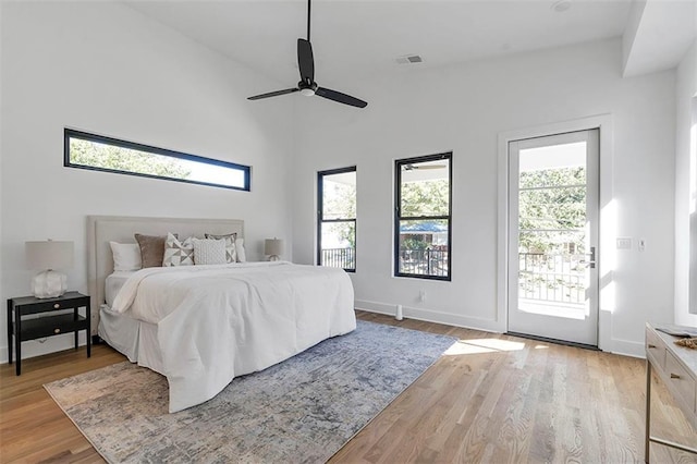 bedroom featuring access to outside, light wood finished floors, visible vents, and baseboards