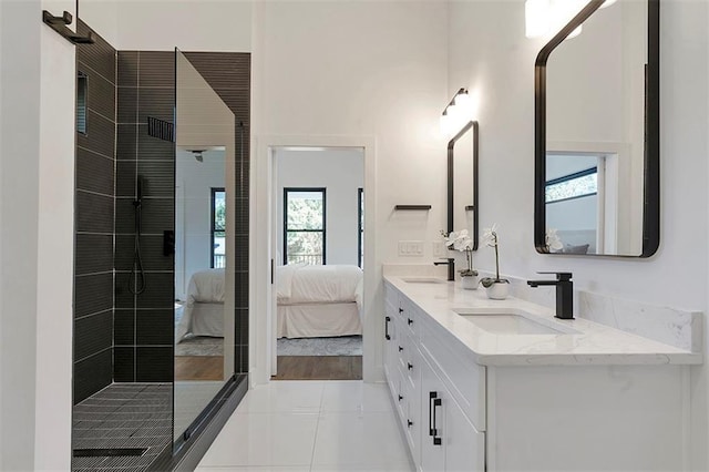 bathroom with tiled shower, a sink, ensuite bath, and double vanity