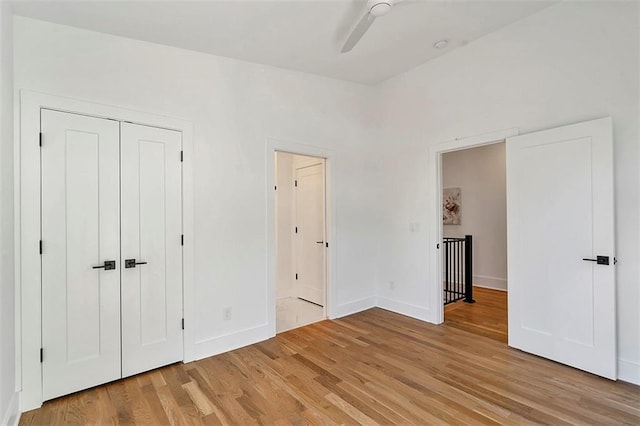 unfurnished bedroom featuring light wood-type flooring, a ceiling fan, and baseboards