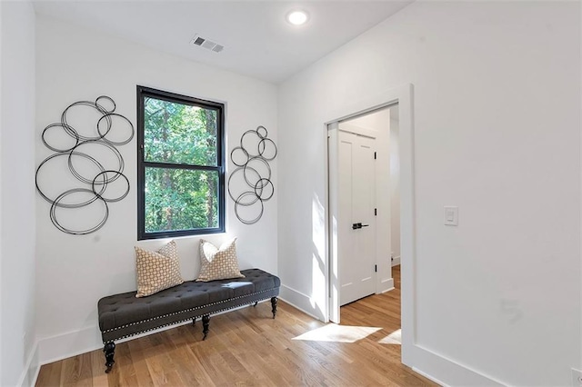 sitting room featuring light wood-style flooring, recessed lighting, visible vents, and baseboards