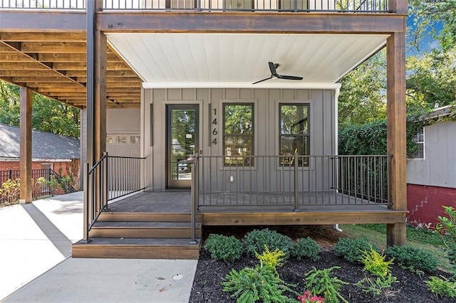 property entrance with board and batten siding, a porch, and a ceiling fan