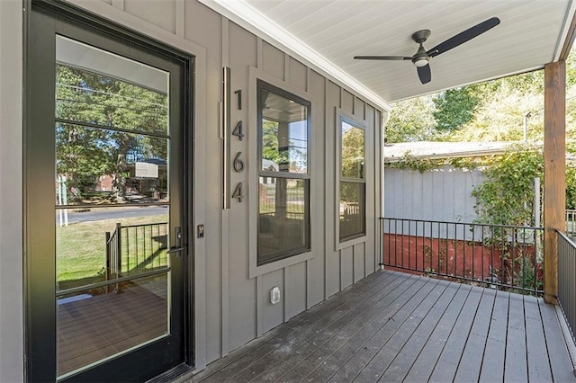 doorway to property featuring board and batten siding and a ceiling fan