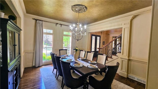 2698 Bonar Hall Path, Duluth, GA 30097 - dining room featuring a chandelier, a decorative wall, dark wood-type flooring, stairs, and ornamental molding