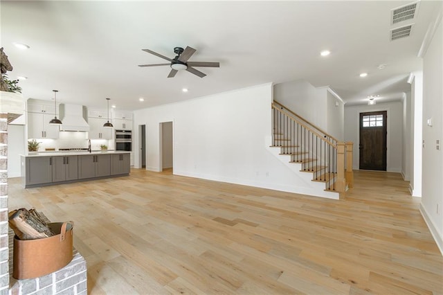 5808 Swinging Gate Rd, Gainesville, GA 30506 - unfurnished living room with ceiling fan, visible vents, stairway, and light wood-type flooring