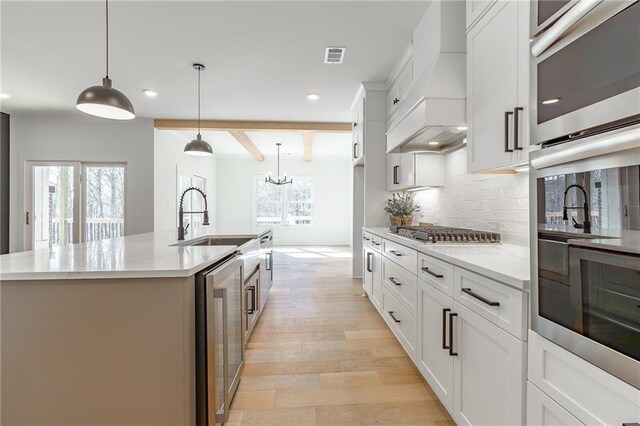 5808 Swinging Gate Rd, Gainesville, GA 30506 - kitchen with custom exhaust hood, beverage cooler, recessed lighting, light wood-type flooring, and appliances with stainless steel finishes