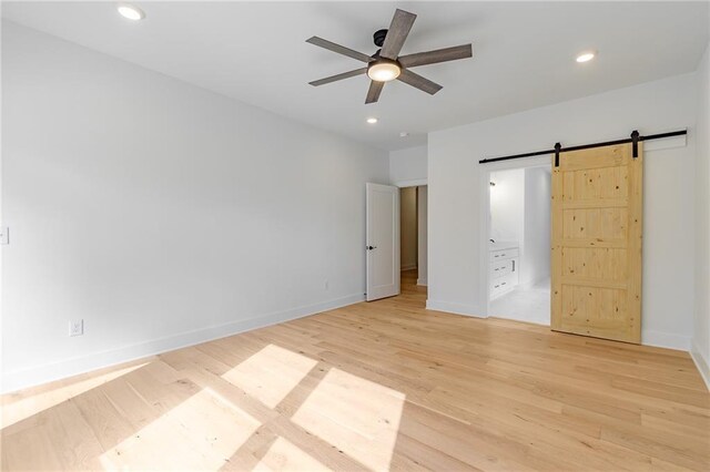 5808 Swinging Gate Rd, Gainesville, GA 30506 - unfurnished bedroom featuring light wood-style floors, a barn door, baseboards, and recessed lighting