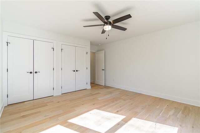 5808 Swinging Gate Rd, Gainesville, GA 30506 - unfurnished bedroom with ceiling fan, baseboards, multiple closets, and light wood-style flooring
