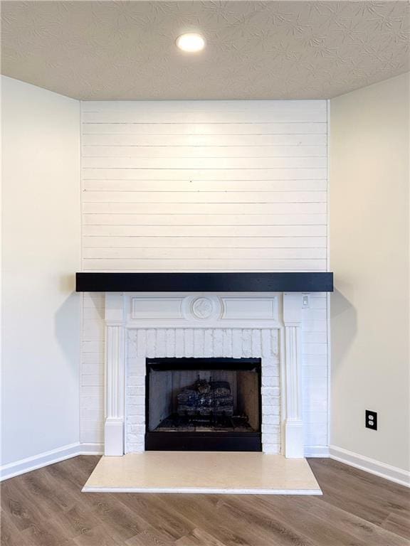 room details featuring a fireplace, a textured ceiling, and hardwood / wood-style flooring