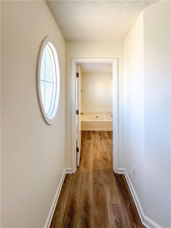 corridor featuring hardwood / wood-style floors and a textured ceiling