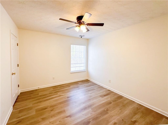 unfurnished room with ceiling fan and hardwood / wood-style flooring