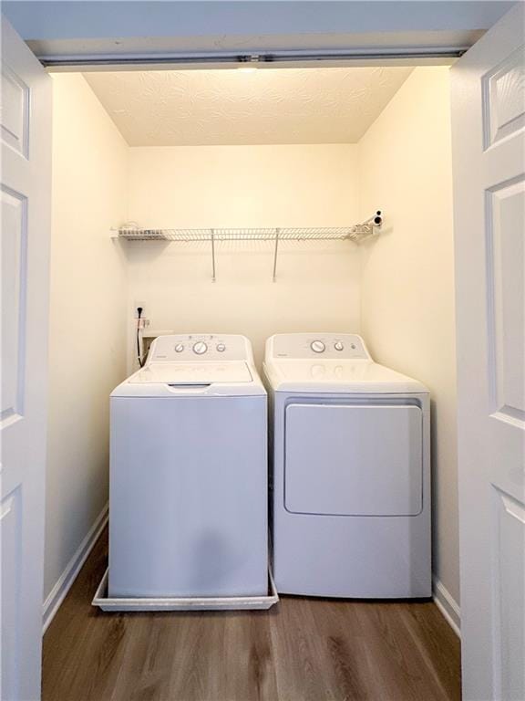 washroom with washer and clothes dryer and dark hardwood / wood-style floors