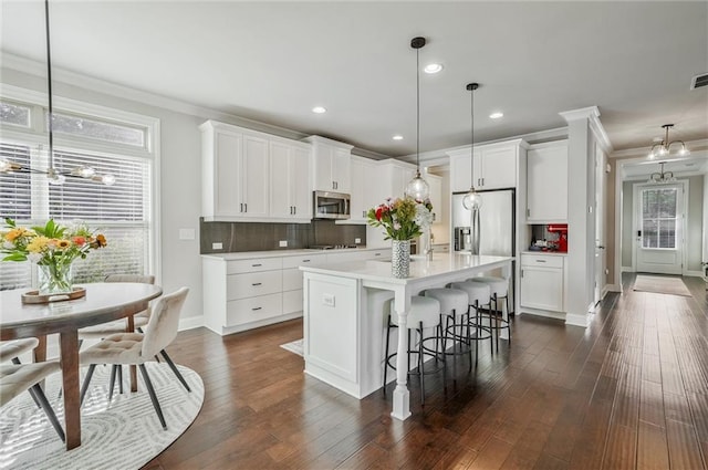 1055 Peyton View Ct, Alpharetta, GA 30004 - kitchen featuring appliances with stainless steel finishes, a chandelier, ornamental molding, tasteful backsplash, and white cabinetry