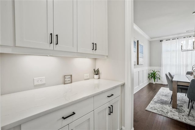 1055 Peyton View Ct, Alpharetta, GA 30004 - kitchen featuring crown molding, white cabinetry, dark wood-style flooring, light stone countertops, and wainscoting