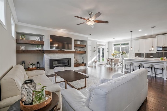 1055 Peyton View Ct, Alpharetta, GA 30004 - living room featuring a ceiling fan, crown molding, dark wood-type flooring, a glass covered fireplace, and recessed lighting