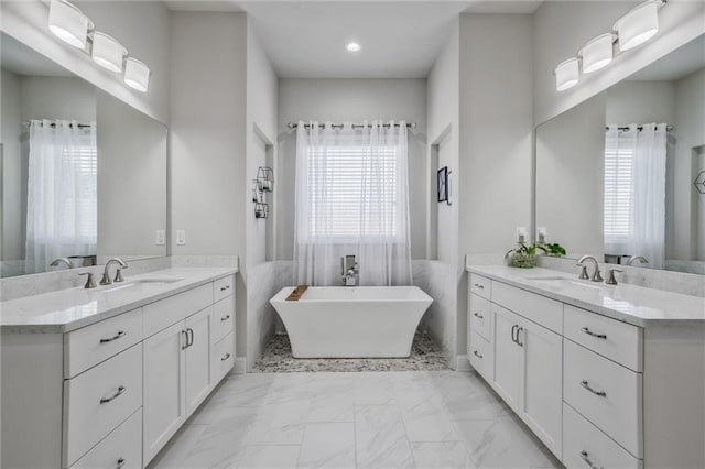 1055 Peyton View Ct, Alpharetta, GA 30004 - full bathroom with two vanities, a soaking tub, marble look tiles, and recessed lighting