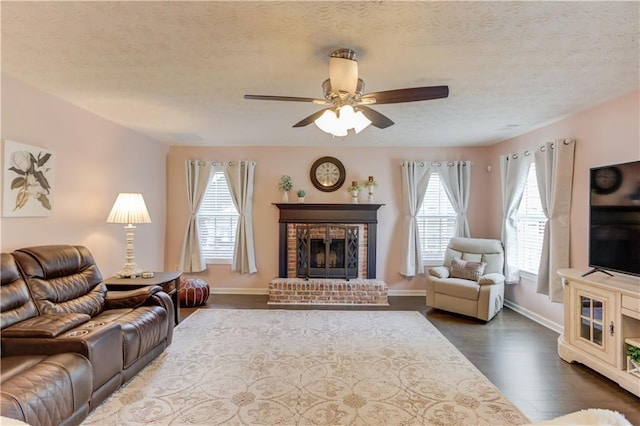 3370 Battlement Cir, Loganville, GA 30052 - living area featuring plenty of natural light, dark wood-style flooring, a textured ceiling, a ceiling fan, and a brick fireplace
