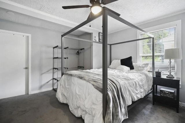 bedroom featuring dark carpet, a textured ceiling, and ceiling fan