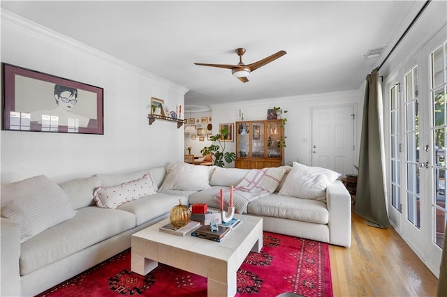 living area featuring visible vents, ceiling fan, light wood-type flooring, ornamental molding, and french doors