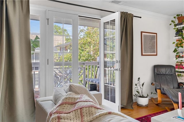 bedroom with access to exterior, multiple windows, crown molding, and wood finished floors