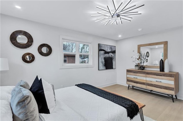 bedroom with a notable chandelier, baseboards, wood finished floors, and recessed lighting