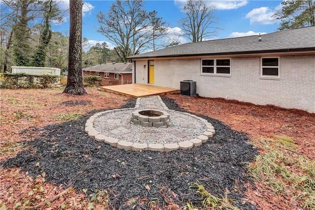 view of yard with an outdoor fire pit, central AC, and a wooden deck