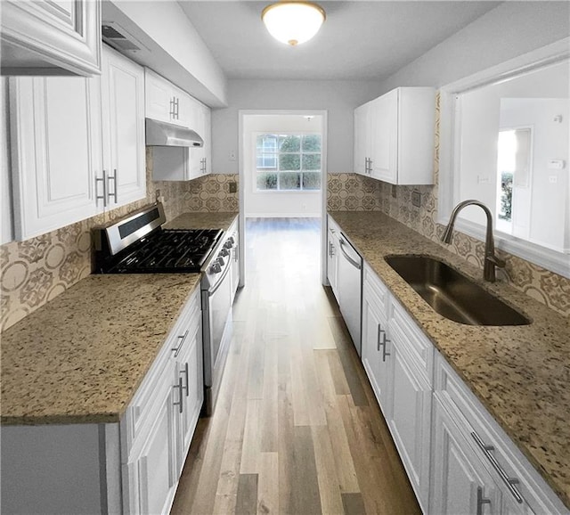 kitchen featuring appliances with stainless steel finishes, white cabinets, tasteful backsplash, and sink