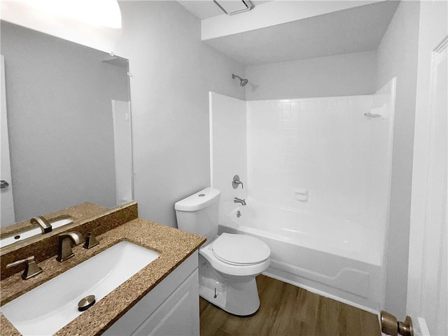 full bathroom featuring washtub / shower combination, wood-type flooring, toilet, and vanity