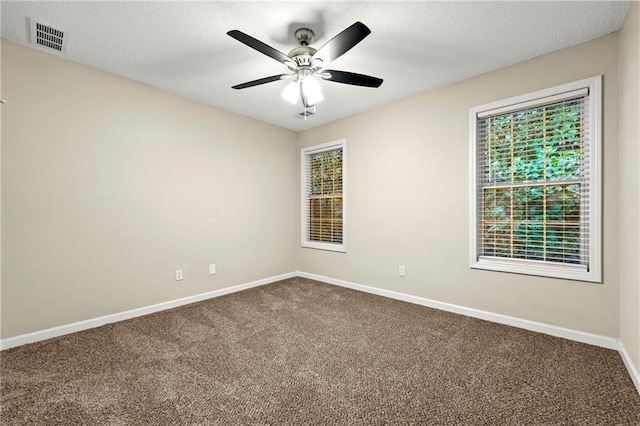 2004 Township Dr, Woodstock, GA 30189 - spare room featuring dark colored carpet, a ceiling fan, and a textured ceiling