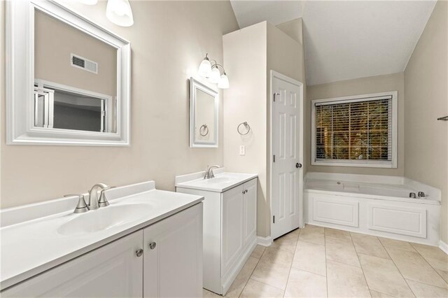 2004 Township Dr, Woodstock, GA 30189 - full bath featuring two vanities, a bath, tile patterned flooring, and vaulted ceiling