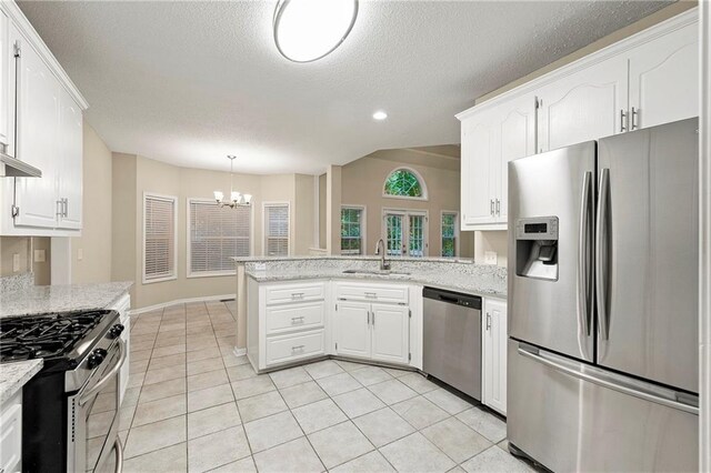 2004 Township Dr, Woodstock, GA 30189 - kitchen with appliances with stainless steel finishes, a chandelier, a peninsula, white cabinetry, and a textured ceiling
