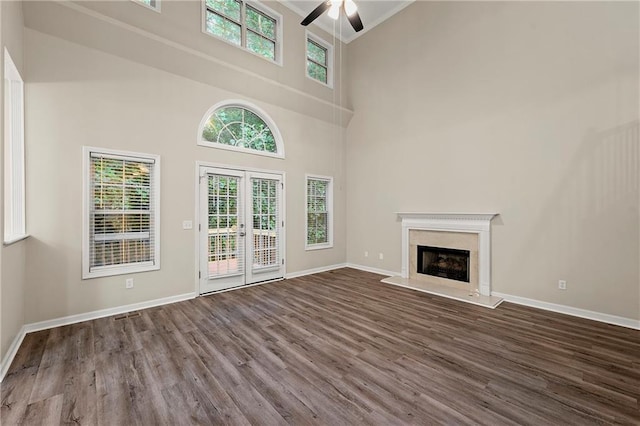 2004 Township Dr, Woodstock, GA 30189 - unfurnished living room with ceiling fan, dark wood-style floors, crown molding, a premium fireplace, and a towering ceiling