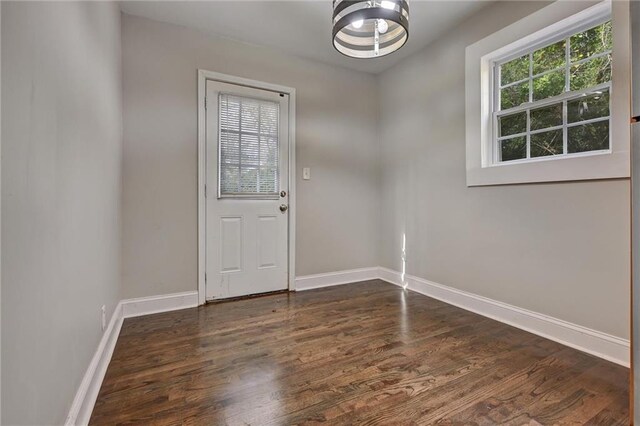 doorway to outside featuring dark hardwood / wood-style flooring and an inviting chandelier