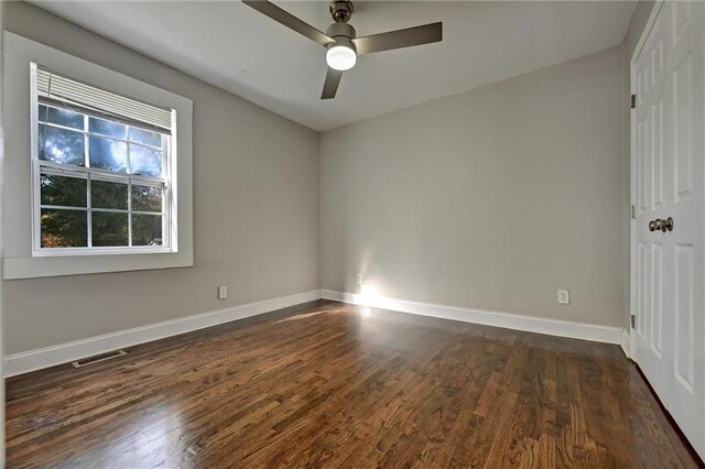 empty room featuring ceiling fan and dark hardwood / wood-style flooring