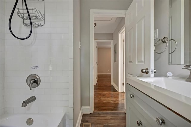 bathroom with vanity, tiled shower / bath combo, and hardwood / wood-style flooring